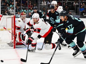Senators defenceman Nick Holden reaches for the puck in front of Kraken forward Jaden Schwartz during the third period of Thursday's game at Seattle.