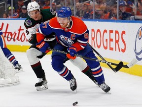 Edmonton Oilers forward Connor McDavid (97) protects the puck from Arizona Coyotes defensemen Michael Kesselring (5) during the first period at Rogers Place on Wednesday, March 22, 2023.