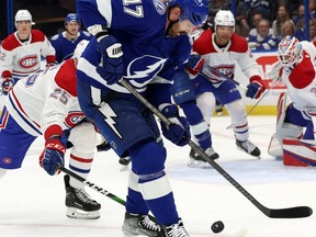 Tampa Bay Lightning forward Alex Killorn tries to control puck while being checked by the Canadiens’ Denis Gurianov during first-period action Saturday night at Amalie Arena.