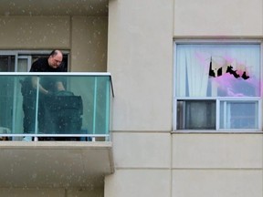 A London, Ont., police forensic investigator searches for evidence on the balcony of an apartment building on Sunday, March 12, 2023.