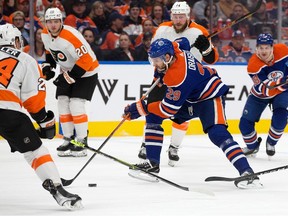 Leon Draisaitl (29) of the Edmonton Oilers battles the Philadelphia Flyers' Nick Seeler (24) during first period NHL action at Rogers Place in Edmonton on Feb. 21, 2023.