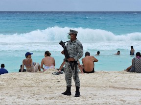 A member of the newly created Tourist Security Battalion of the National Guard stands guard at a beach in Cancun, Quintana Roo State, Mexico, on Dec. 2, 2021.