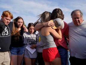 Community members embrace each other during a vigil the day after a shooting during a teenager's birthday party at Mahogany Masterpiece Dance Studio in Dadeville, Alabama, Sunday, April 16, 2023.
