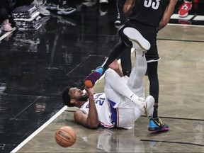 Philadelphia 76ers centre Joel Embiid falls to the floor after colliding with Brooklyn Nets centre Nic Claxton during game three of the 2023 NBA playoffs at Barclays Center in Brooklyn, N.Y., April 20, 2023.