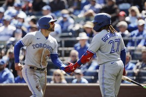 Blue Jays' Kevin Kiermaier (left) is congratulated by Vladimir Guerrero Jr. at home plate after scoring off a Bo Bichette single during the second inning against the Kansas City Royals in Kansas City, Mo., Thursday, April 6, 2023.