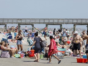 In this file photo taken on March 20, 2020, beach goers enjoy the Isle of Palms beach in Isle of Palms, S.C.