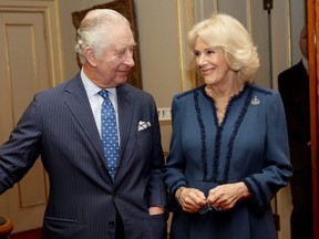 King Charles III and Camilla, Queen Consort, laugh during a reception to celebrate the second anniversary of The Reading Room at Clarence House in London, England, Feb. 23, 2023.