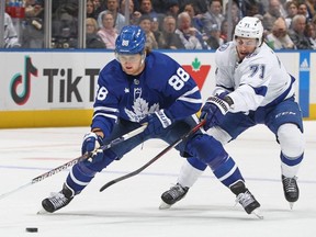 Lightning forward Anthony Cirelli, right, skates to contain Maple Leafs forward William Nylander, left, during first period NHL action at Scotiabank Arena in Toronto, Dec. 20, 2022.
