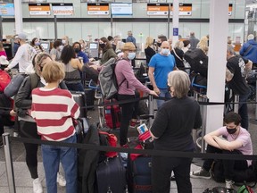 Travellers wait in line at a check-in desk at Trudeau Airport in Montreal, Wednesday, April 20, 2022.