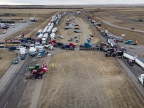 Anti-mandate demonstrators gather as a truck convoy blocks the highway the busy U.S. border crossing in Coutts, Alta., Monday, Jan. 31, 2022.