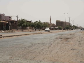A vehicle crosses an empty street in Khartoum, Sudan, Saturday, April 29, 2023, as gunfire and heavy artillery fire continued despite the extension of a cease-fire between the country's two top generals.