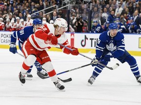 Detroit Red Wings' Jonatan Berggren (left) scores on Maple Leafs goaltender Matt Murray, not shown, as Maple Leafs' Justin Holl and centre John Tavares defend during the first period in Toronto on Sunday, April 2, 2023.