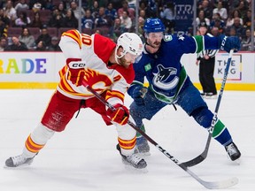 Vancouver Canucks defenseman Kyle Burroughs defends against Calgary Flames forward Jonathan Huberdeau in the second period at Rogers Arena.