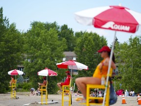 Lifeguards work at Brittany Beach of the Ottawa River in Ottawa, Friday, June 24, 2022.&ampnbsp;Ontario is proposing to lower the minimum age for lifeguards to 15, in part to address staff shortages many municipalities experienced last summer.