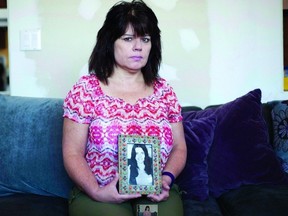 Janine Stearne holds up a photo of her oldest sister Donna Lee Stearne at her home in Waterloo, Ont. on April 27, 2016. Stearne's oldest sister, Donna Lee Stearne, was murdered in 1973 in Toronto and the case is still unsolved.