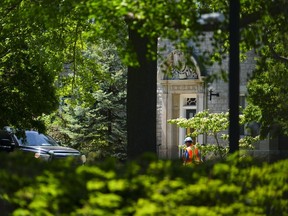 A construction worker walks past the front entrance to 24 Sussex Drive in Ottawa on Monday, May 29, 2023.