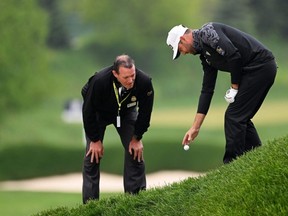 Corey Conners takes a drop as PGA Rules Official Mike Raby looks on after Conners' ball was imbedded on the 16th hole during the third round of the 2023 PGA Championship at Oak Hill Country Club in Rochester, N.Y., Saturday, May 20, 2023.