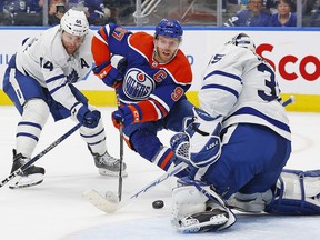 Maple Leafs goaltender Ilya Samsonov makes a save on Oilers' Connor McDavid with defenceman Morgan Rielly trying to help, during the third period at Rogers Place on Wednesday night.