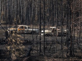 Burnt out trucks from a wildfire sit on a property near Drayton Valley, Alta., Wednesday, May 10, 2023.
