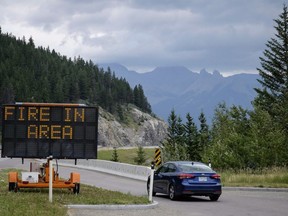 A sign warns of a forest fire in the area as smoke haze from forest fires burning in Alberta and British Columbia hangs over the Banff townsite in Banff National Park on July 21, 2017.