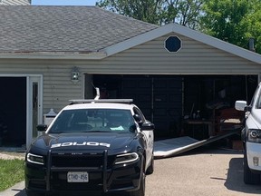 A broken garage door litters the driveway of a Stoney Creek home on Monday, May 29, 2023, where two people were slain and their alleged killer was shot to death by police over the weekend.