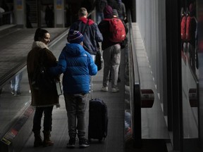 People make their way through Pearson Airport in Mississauga, Ont., March 14, 2023. A new survey ranks Canada's two biggest airlines below the average for customer satisfaction among major North American carriers.