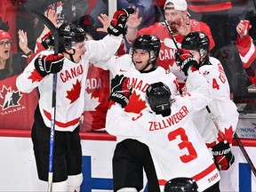 Adam Fantilli (19) of Team Canada celebrates his goal with teammates Caedan Bankier (18), Olen Zellweger (3) and Ethan del Mastro (24) during the second period against Team USA in a semifinal at the IIHF world junior championship Wednesday at Scotiabank Centre in Halifax.