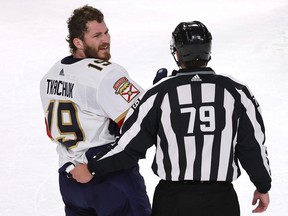 Matthew Tkachuk of the Florida Panthers is escorted off the ice by linesman Kiel Murchison.