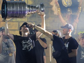 Vegas Golden Knights' Chandler Stephenson gives Mark Stone a drink as he hoists the Stanley Cup.