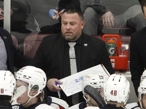 Windsor Spitfires' head coach Marc Savard goes over a play during a timeout.