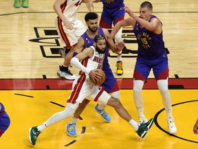 Caleb Martin #16 of the Miami Heat drives to the basket against Jamal Murray #27 and Nikola Jokic #15 of the Denver Nuggets during the first half in Game Three of the 2023 NBA Finals at Kaseya Center on June 07, 2023 in Miami.