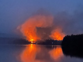 A wildfire burns near to Centennial Lake, near Matawatchan, Ont., on Sunday, June 4, 2023. The wildfire burning around Centennial Lake, about 150 kilometres west of Ottawa, was one of the 21 new fire starts in Ontario since Sunday, said fire advisor Shayne McCool, with the Ministry of Natural Resources and Forestry.