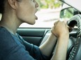 Angry woman driver yelling at other cars on the road.