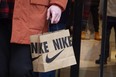 A shopper leaves a Nike store along the Magnificent Mile shopping district with a purchase on December 21, 2022 in Chicago, Illinois. (Photo by Scott Olson/Getty Images)