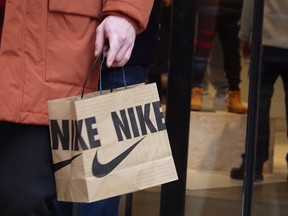 A shopper leaves a Nike store along the Magnificent Mile shopping district with a purchase on December 21, 2022 in Chicago, Illinois. (Photo by Scott Olson/Getty Images)