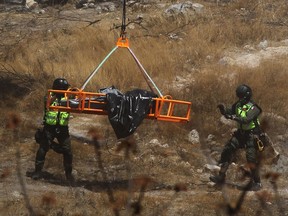 Forensic experts work with several bags of human remains extracted from the bottom of a ravine by a helicopter in Zapopan, Jalisco state, Mexico on May 31, 2023.