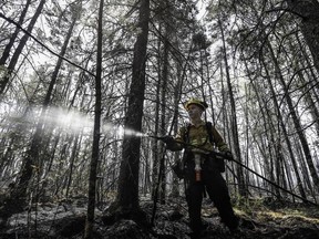 Department of Natural Resources and Renewables firefighter Kalen MacMullin of Sydney, N.S. works on a fire in Shelburne County, N.S. in a Thursday, June 1, 2023 handout photo.