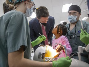 Four-year -old Amanda Ibeya throws a perturbed look at Justin Trudeau after the Prime Minister interrupted her while she was playing with dental student tools at Western University's Schulich School of Medicine and Dentistry in London, Ont. on Dec. 1, 2022.