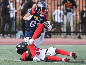 Alouettes receive Austin Mack is tackled by Redblacks defensive back Abdul Kanneh in the first half of Saturday's game at Montreal.