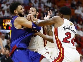 Jamal Murray of the Denver Nuggets battles for the ball against Haywood Highsmith and Caleb Martin of the Miami Heat during Game 3 of the NBA Finals at Kaseya Center on June 7, 2023 in Miami.