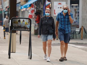 OTTAWA - June 6, 2023 - Debbie Wallace and Paul Gecius walk in the Byward Market in Ottawa with their masks on due to the poor air quality Tuesday. TONY CALDWELL, Postmedia.