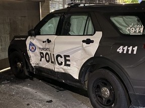 A police cruiser is seen with damage to its driver-side door.