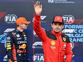 Ferrari's Charles Leclerc waves after clocking second fastest lap flanked by fastest lap winner, Red Bull Racing's Max Verstappen.