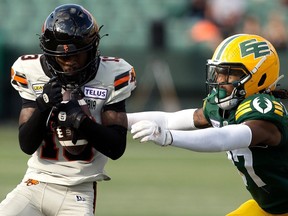 The B.C. Lions' Alexander Hollins (13) makes a catch against the Edmonton Elks' Dwayne Thompson II (37) during first half CFL action at Commonwealth Stadium, in Edmonton Saturday July 29, 2023. Photo by David Bloom
