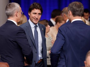 Canada's Prime Minister Justin Trudeau (C) talks with NATO Secretary General Jens Stoltenberg (L) and Belgium's Prime Minister Alexander De Croo (R) at the start of a meeting of the North Atlantic Council (NAC) with Asia Pacific partners during the NATO Summit in Vilnius, Lithuania, on July 12, 2023.
