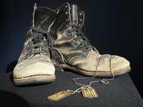 Combat boots and dog tags worn by Alan Alda as he portrayed the wisecracking surgeon Hawkeye on the beloved television series "M-A-S-H" are displayed at Heritage Auctions in Irving, Texas, Wednesday, July 5, 2023.