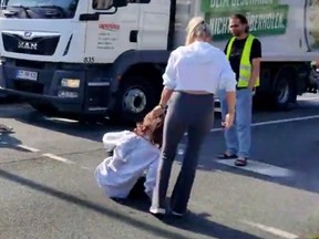 A climate activist is pulled off the road by her hair by a woman frustrated by the protest in Germany last week.