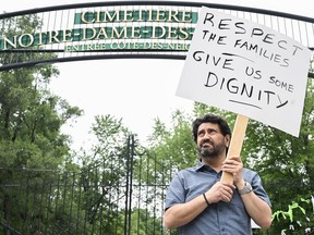 Jimmy Koliakoudakis holds up a sign during a protest outside Notre-Dame-des-Neiges Cemetery in Montreal, Sunday, July 9, 2023.