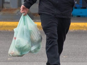 A shopper leaves a grocery store in Calgary on Oct. 7, 2020.