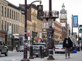 A man walks down the sidewalk in Peterborough, Ont., April 17, 2020.